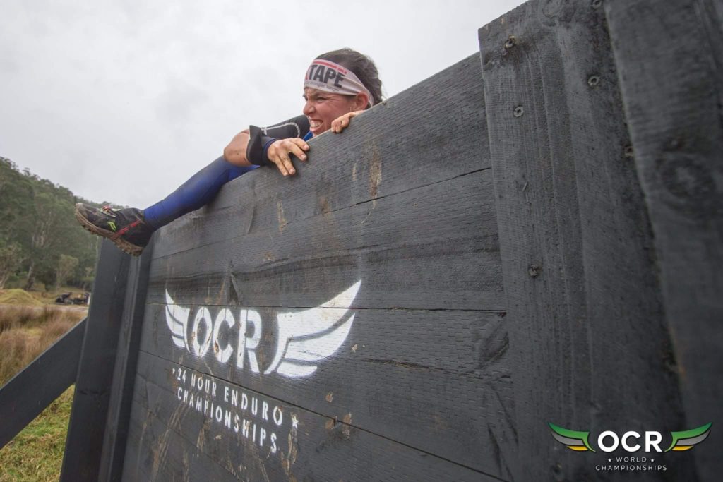 An OCR racer attempting to climb up a wall at the Enduro race. 
