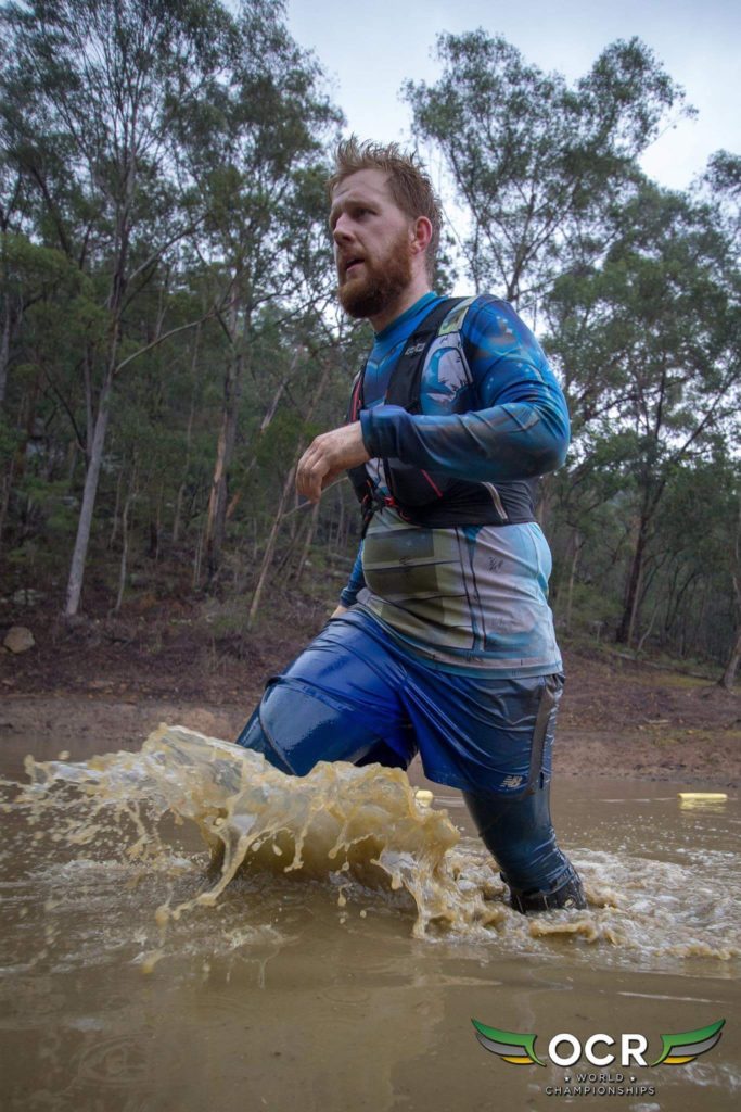 A man traveling through water obstacles in the Enduro obstacle course race. 